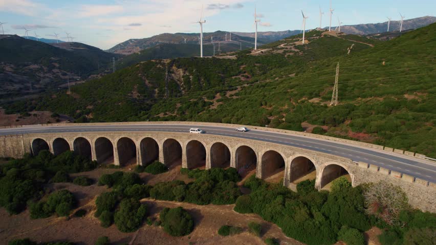 Bridge in the mountains of Tarifa in the province of Cadiz, Spain. Beautiful mountains with windmills. Renewable energy. | Shutterstock HD Video #1101611137