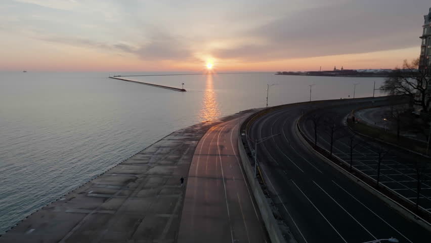 Aerial view following a man running on the Lakefront Trail, sunrise in Chicago, USA | Shutterstock HD Video #1101611167