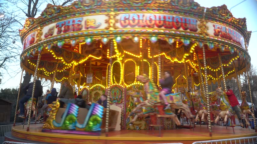 The camera zooms in on a bright carousel at an amusement park Royalty-Free Stock Footage #1101611235