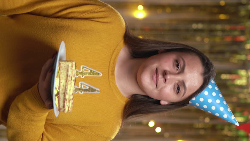 Beautiful happy young woman wearing sweater holding birthday cake number 44 golden candles burning by lighter. Concept of celebrating birthday and anniversary. POV.