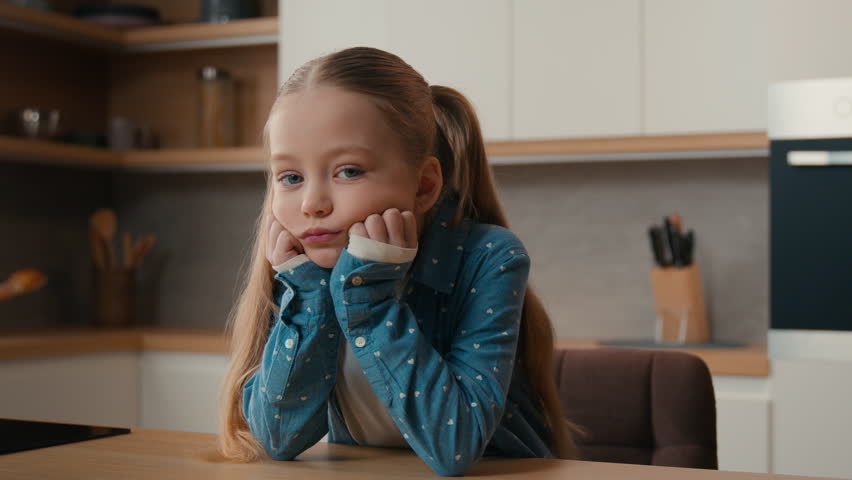 Moving camera portrait sad little offended Caucasian child girl kid at kitchen say no answer not never shaking head negative disagree family misunderstanding upset daughter unhappy displeased at home Royalty-Free Stock Footage #1101612911
