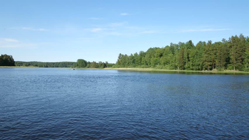 A motor boat is approaching on the waves on the lake against the background of the forest | Shutterstock HD Video #1101613097