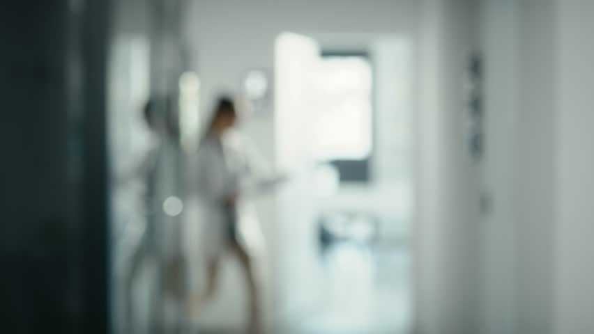 Blurred video of medical staff walking across the hospital corridor. Shot with RED helium camera in 8K. Royalty-Free Stock Footage #1101613985