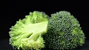 Macro broccoli slices rotating over black background. Fresh broccoli cabbage rotating closeup.