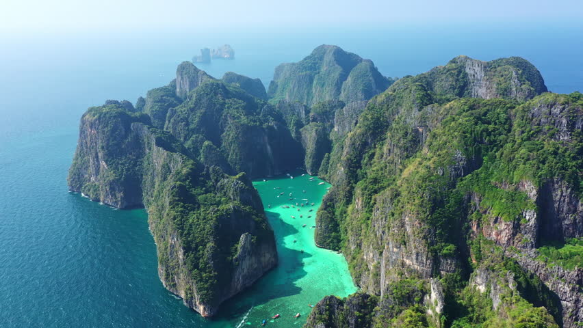 Aerial view of Koh Phi Phi   
island and the blue-green waters of Thailand with many tourist boats. | Shutterstock HD Video #1101614619
