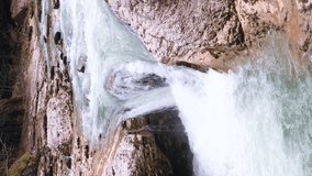 Amazing waterfall Falling water hitting water surface some huge rocks with an observation area. Vertical video. The concept of travel, outdoor activities, adventure, tourism, vacation. 4k