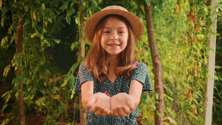 Portrait of a cute caucasian smiling girl catching passion fruit. Slow motion. Concepts of summer and gardening. | Shutterstock HD Video #1101615451