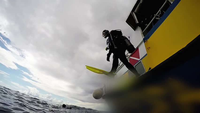Boat Diving - Scuba Diver Jumps from a Dive Boat. Scuba Diver in Action. Open Water Diving. Scuba Diving Tourism. Health Benefits of Scuba Diving. High speed Camera Shot. Active Lifestyle.