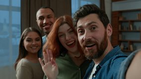 Bearded man blogger hold mobile phone invite friends colleagues group photo diverse multiracial men women looking at smartphone camera smiling laughing make funny selfie record video blog webcam view - Powered by Shutterstock - Get 15% off with code: PIKWIZARD15