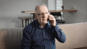 Elderly man at home, talking on the phone. A pensioner uses a smartphone to communicate with his family - Powered by Shutterstock - Get 15% off with code: PIKWIZARD15