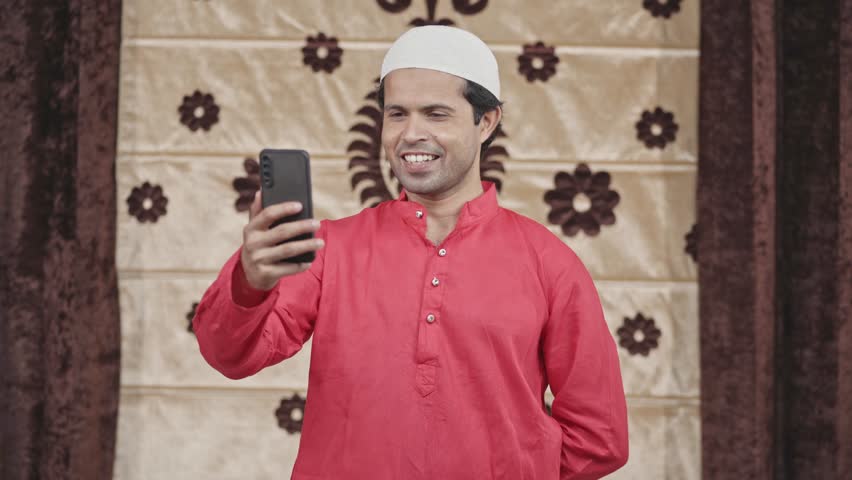 Happy Muslim man talking to someone on a video call