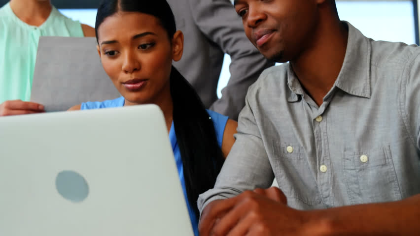 Animation of clock ticking over diverse business people using laptop. Global business, finances, computing and data processing concept digitally generated video.