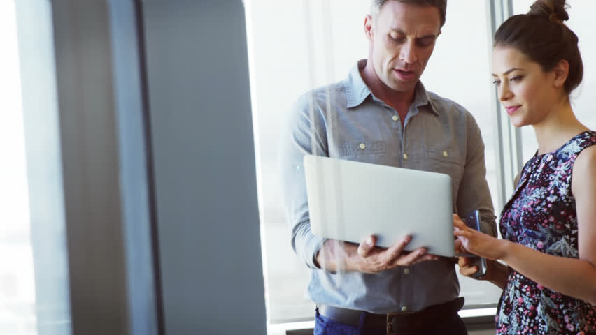 Animation of clock ticking over diverse business people using laptop. Global business, finances, computing and data processing concept digitally generated video.