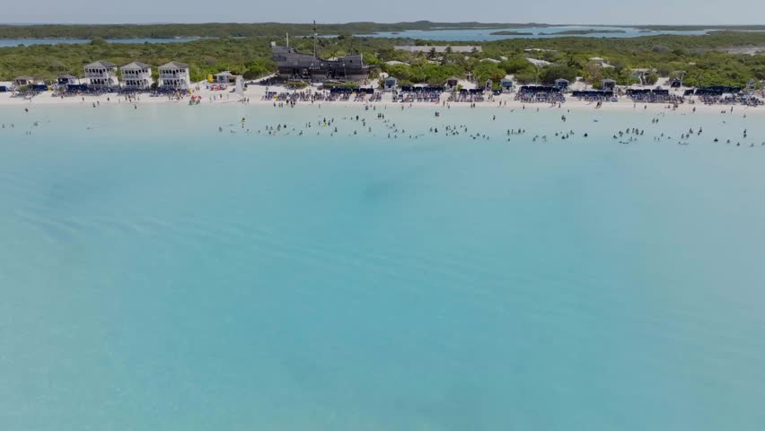 Aerial view of people at the Half Moon beach, in sunny Little San Salvador Island, Bahamas