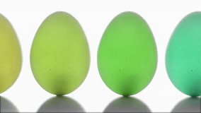 Multi-colored eggs move across the screen on a white background. Close-up of fresh, organic and healthy chicken eggs. Easter eggs clean background.