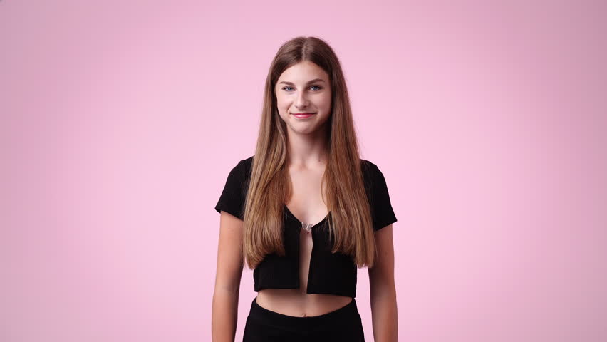 4k video of girl with cunning facial expression on pink background.