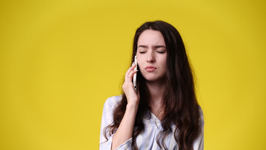 4k video of one girl talking over the phone on yellow background. | Shutterstock HD Video #1101641391