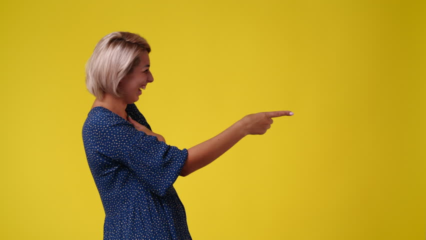 4k video of one woman pointing at right over yellow background. | Shutterstock HD Video #1101641413