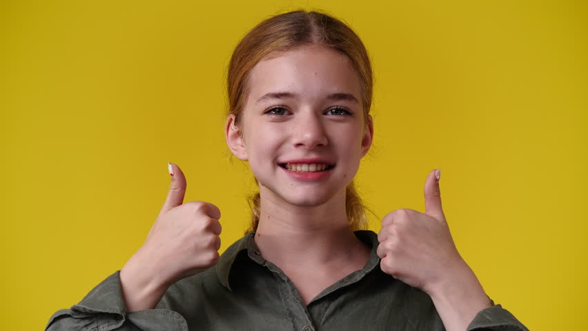4k video of one girl showing thumbs up over yellow background. | Shutterstock HD Video #1101641423