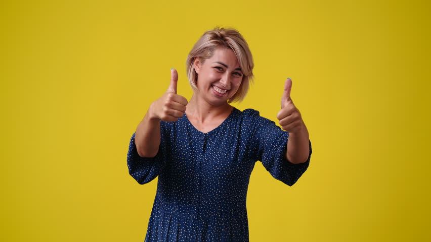 4k video of one woman thowing thumb up over yellow background. | Shutterstock HD Video #1101641429