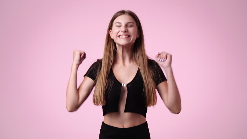 4k video of girl raising hands in surprise looking at camera with big eyes on pink background. | Shutterstock HD Video #1101641431