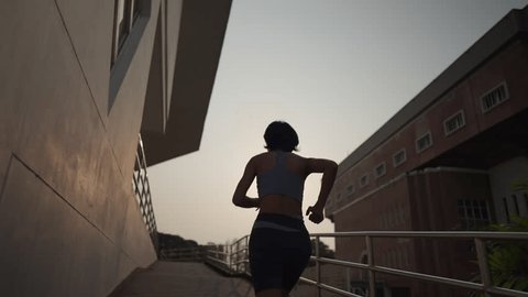Asian short hair woman athlete running up the stairs training workout exercise male runner legs jogging on steps in urban city background 스톡 비디오