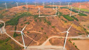 Aerial view from a drone flying above a wind turbines, typically installed in areas with consistent, strong winds, such as coastal areas or open plains, to ensure maximum energy production. 4K
