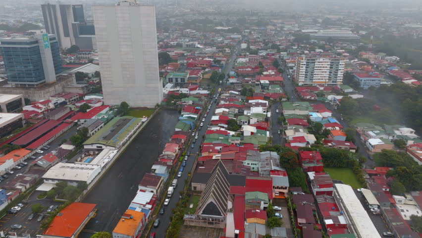 High angle view of urban borough. houses. Low residential houses and multistorey buildings in capital on hazy day. San Jose, Costa Rica