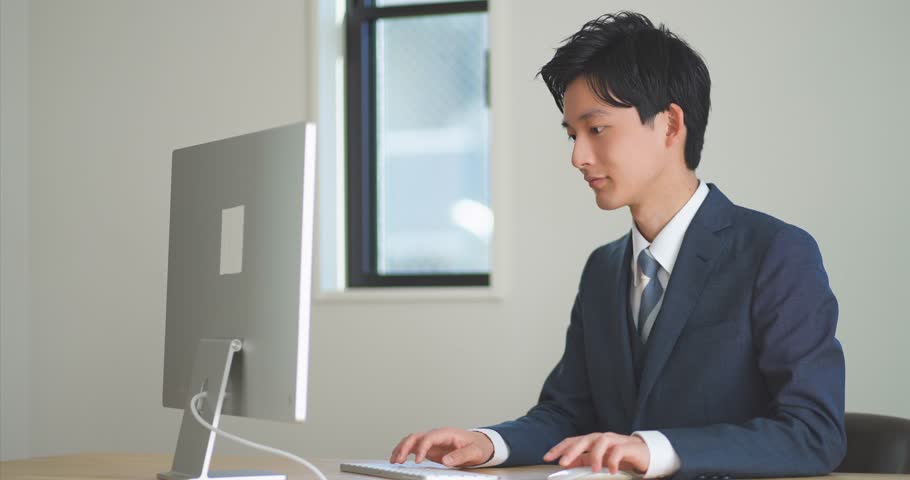 A young man in a suit working at a desk