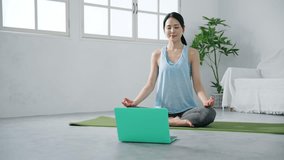 Young Asian woman exercising with laptop PC in the room. Remote training. Body care.
