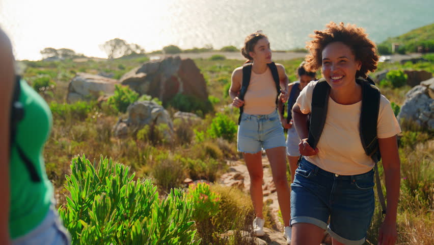 Group of female friends with backpacks helping each other on hiking vacation in countryside - shot in slow motion Royalty-Free Stock Footage #1101666189