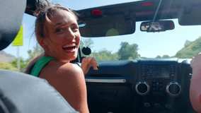 Group of female friends in open top car laughing on road trip through countryside - shot in slow motion - Powered by Shutterstock - Get 15% off with code: PIKWIZARD15