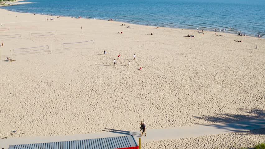 Drone video of Lake Michigan on a sunny day with people playing on the beach