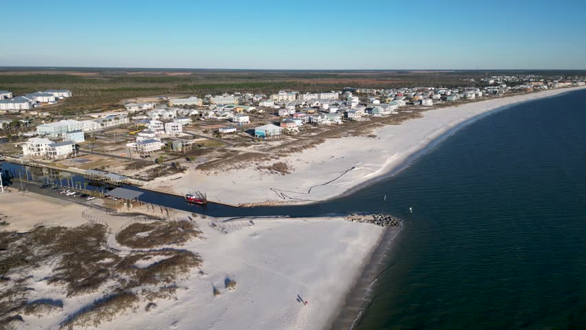 panning drone view from over water of Mexico beach Florida showing white sands and rebuilding four years after hurricane Michael.
