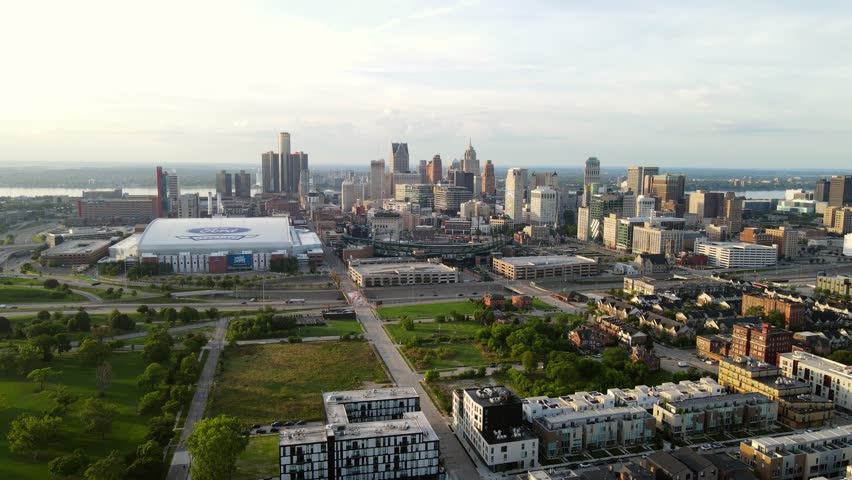 Aerial forwarding shot of urban green space, downtown Detroit with Comercia baseball park and Ford football field