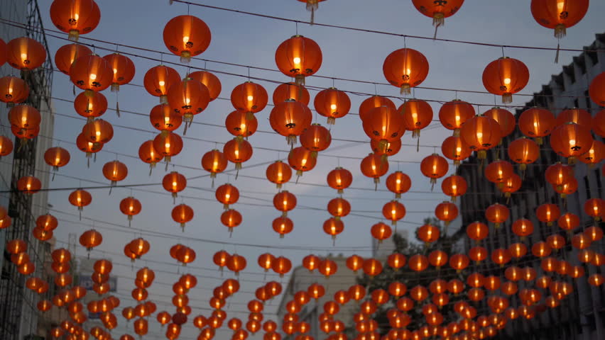 Red chinese lanterns hanging on wire outdoor lamps in temple of China Town decoration on Chinese New Year festival culture with blue sky at night background in Asia.