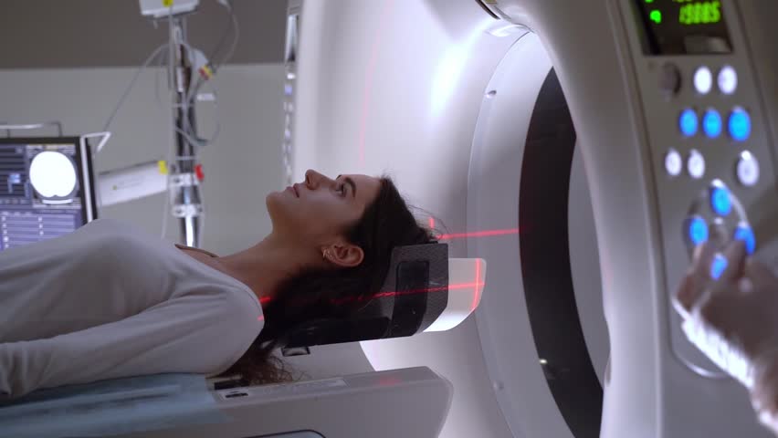Video CT scan of brains of woman in medical clinic. Girl patient is doing computed tomography x-ray examination of tumor in his head in a CT scan room. Royalty-Free Stock Footage #1101680471