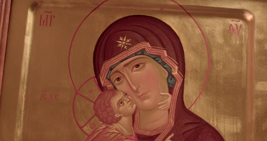 Madonna is depicted holding her infant son Christ. Represents the ideal of motherhood and is a symbol of the Church. Close-up image of religious content.