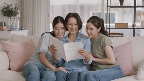 Buy mediclaim health care life insure for older mum. Young adult woman asia people grown up child give gift to middle aged mom reading protect cover saving plan paper smile laugh sitting at sofa home. - Powered by Shutterstock - Get 15% off with code: PIKWIZARD15