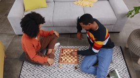 Chess, game and couple on floor in home playing board games for bonding, relax and quality time. Love, top view and happy black man and woman in living room having fun, problem solving and strategy - Powered by Shutterstock - Get 15% off with code: PIKWIZARD15