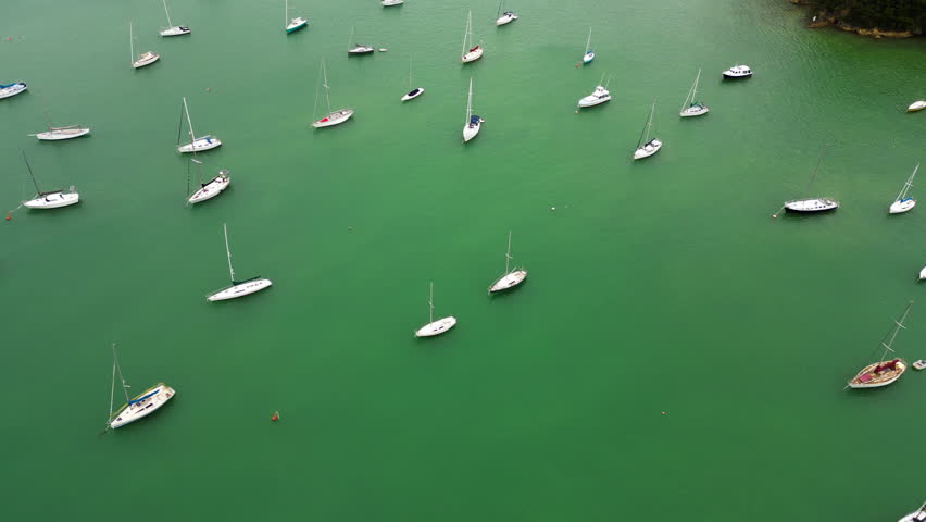 aerial view of ocean water with sail boat in russel bay north island of New Zealand , drone fly above boat moored on the coastline