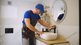 Jack of all trades repairs the faucet in the bathroom. The concept of maintenance and home help.  - Powered by Shutterstock - Get 15% off with code: PIKWIZARD15