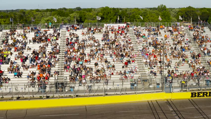 Fans watching a car race on a sunny day
