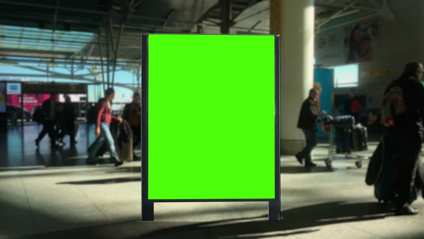 Airport Panel Green Screen People Walking Behind Billboard. Panel green screen inside an airport with people walking behind. Pre Keyed Royalty-Free Stock Footage #1101700283