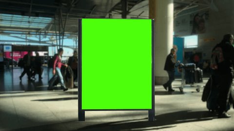 Airport Panel Green Screen People Walking Behind Billboard. Panel green screen inside an airport with people walking behind. Pre Keyed : vidéo de stock
