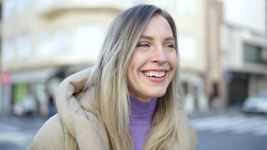 Young blonde woman smiling confident standing at street