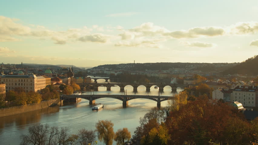 landscape with Vltava river, Karlov most and boat in the evening in autumn in Prague, Czech Republic.