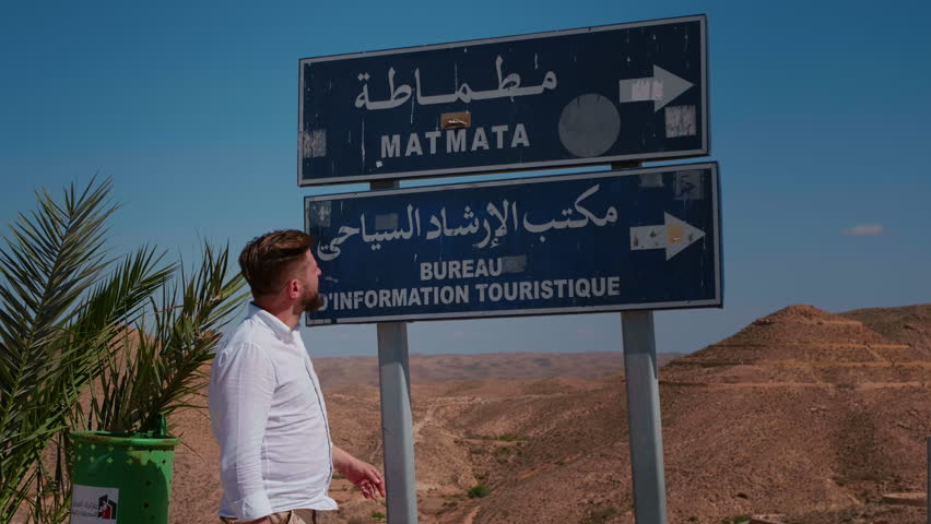Street sign showing the name of the city Matmata in English and native language. Man showing the direction of the city. Easy acces to the city with direction simbols.