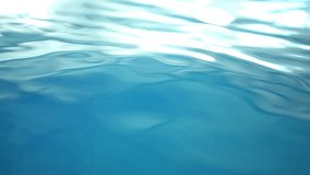 Close-up waves of swimming pool in sunbeam indoors. Blue water moving in slow motion reflecting sunlight - Powered by Shutterstock - Get 15% off with code: PIKWIZARD15