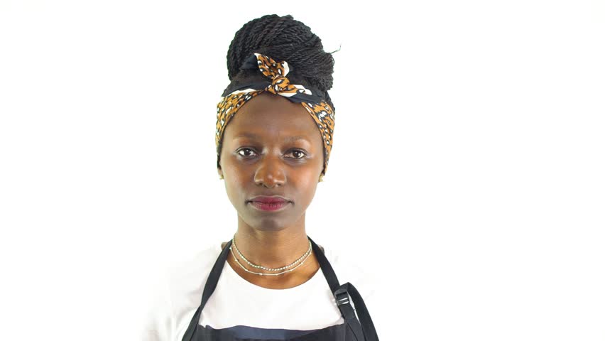 Young female chef using a metal ladle while smiling and looking at camera. Isolated on a white background